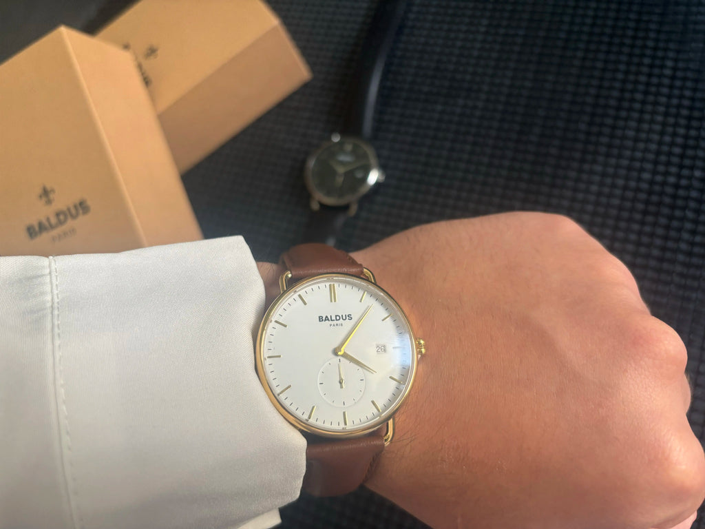 Montre élégante made in France posée sur un poignet masculin, avec fond parisien flou.